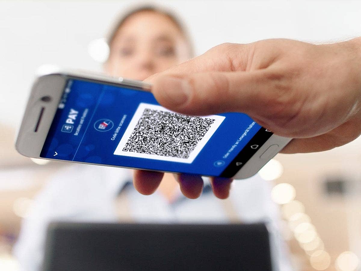 Ein Handy mit einem QR-Code wird über einen Scanner gehalten