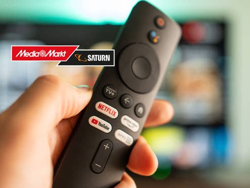Person hält eine Fernbedienung daneben das MediaMarkt-Logo