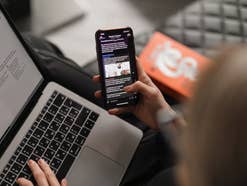 Person nutzt parallel Handy und Laptop Person nutzt parallel Handy und Laptop