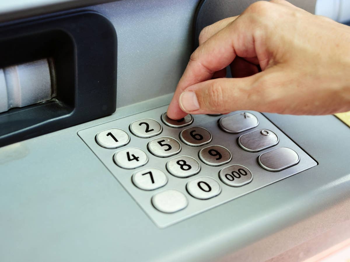 Bankautomat PIN-Eingabe Person tippt PIN-Code im Bankautomat ein