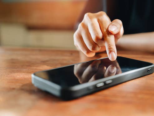 Person zeigt mit Finger auf Smartphone Person zeigt mit Finger auf Smartphone