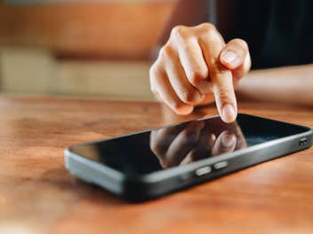 Person zeigt mit Finger auf Smartphone