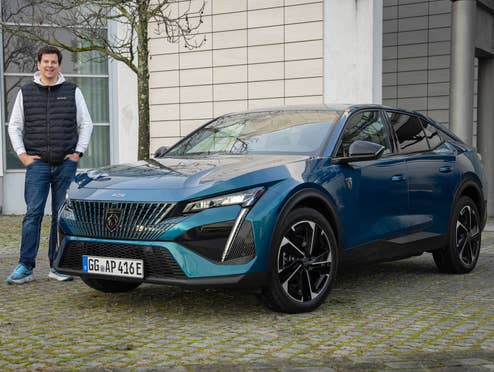 Hayo Lücke neben dem Peugeot E-408.