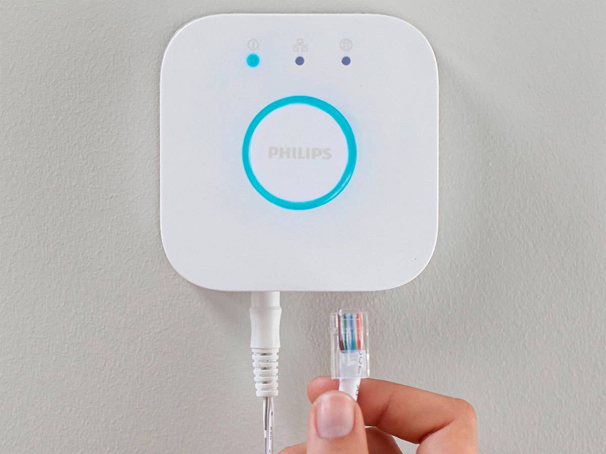 Ein LAN-Kabel wird in eine Philips Hue Bridge eingesteckt