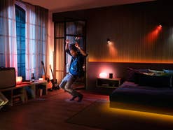 Ein Mann tanzt zu Musik mit bunten Philips Hue Lampen