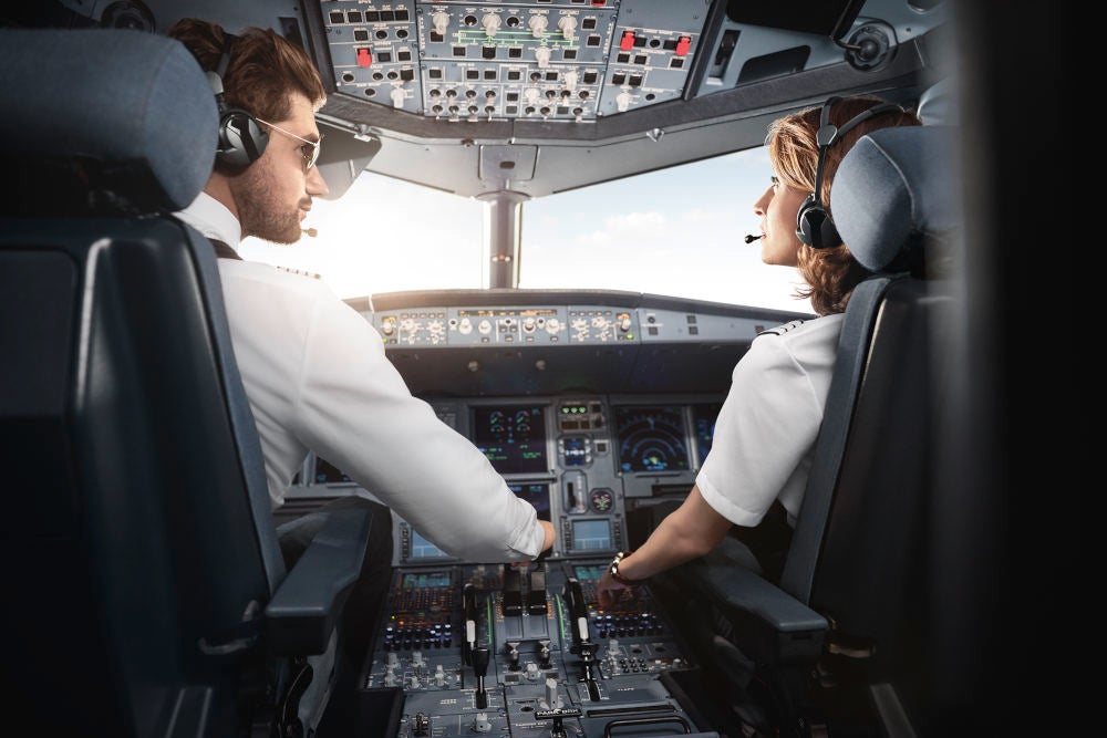 Pilot und Co-Pilotin im Cockpit eines Airbus.