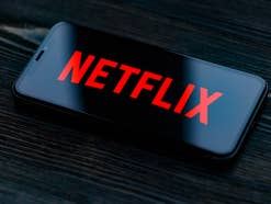 Netflix-Logo auf einem Smartphone-Display vor dunklem Hintergrund.