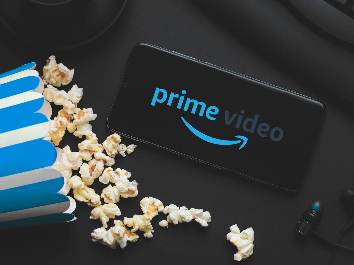 Prime Video auf einem Smartphone neben einer umgekippten Tüte Popcorn.