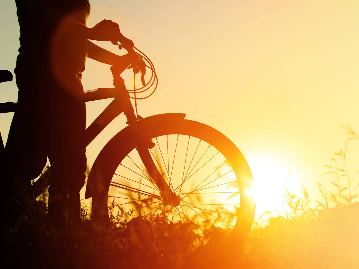 Fahrrad steht vor einem Sonnenaufgang.