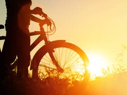 Fahrrad steht vor einem Sonnenaufgang.