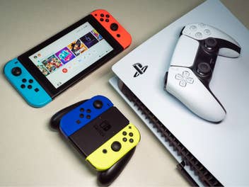 Eine PS5 und eine Nintendo Switch liegen auf einem Tisch.
