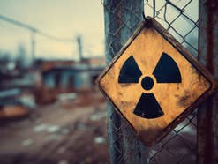 Ein Schild an einem Metallzaun weist auf Radioaktivität hin