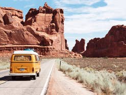 Ein alter VW-Bus fährt auf einer Straße durch die Steppe während einer Reise.