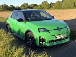 Renault 5 E-Tech statisch auf einem Feldweg im Sonnenlicht.