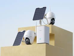 Überwachungskamera-Set mit Solar-Panel und Hub von Reolink auf einem Podest.