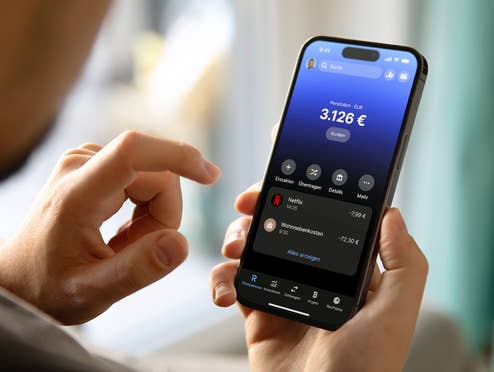 Ein Mann hält ein Samrtphone mit der Revolut App