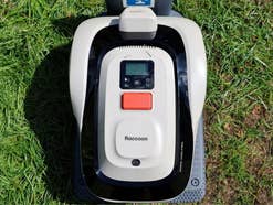 Der RoboUP Raccoon 2 SE Mähroboter steht auf einer Wiese