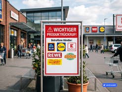 Parkplatz vor Supermärkten mit Warnhinweisschild über einen Rückruf bei mehreren Supermärkten und Discountern