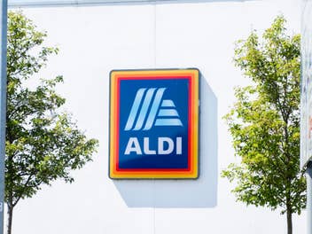 Aldi-Logo an einer Fassade im Sonnenlicht.
