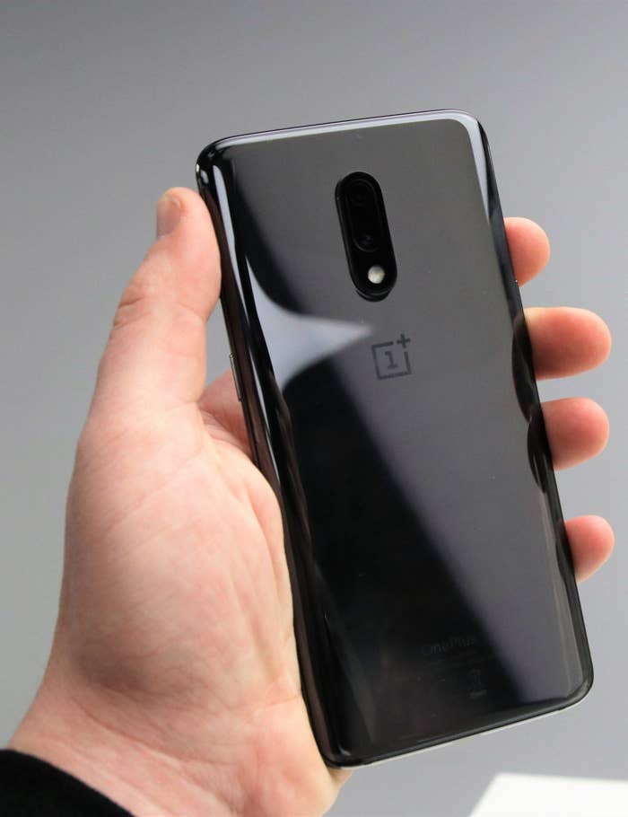 Die hintere Seite des OnePlus 7 in der Hand gehalten.