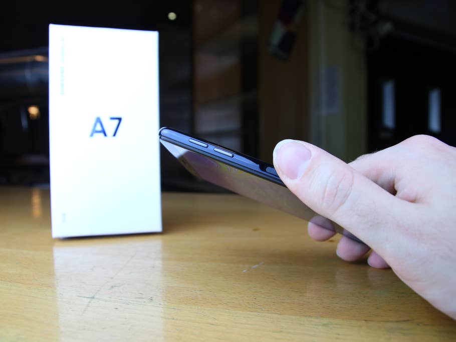 Das Samsung Galaxy A7 (2018) von der Seite mit einem Finger auf dem Fingerabdruck-Sensor