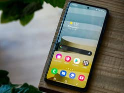 Das Samsung Galaxy A72 auf einem Holzuntergrund mit aktivem Display.