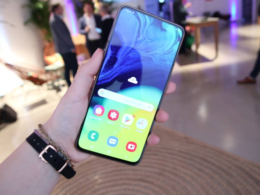 Das Smartphone Samsung Galaxy A80 mit eingeschaltetem Display in der Hand einer Frau