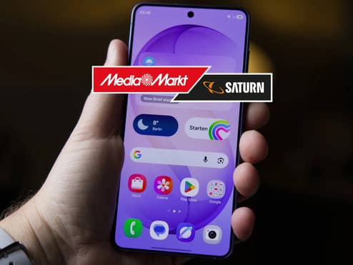 Samsung Galaxy S26 in einer Hand, davor das MediaMarkt-Logo