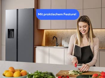 Frau steht in einer Küche, Kühlschrank von Samsung steht im Hintergrund