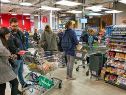 Mehrere Kassen im Supermarkt und Kunden, die anstehen
