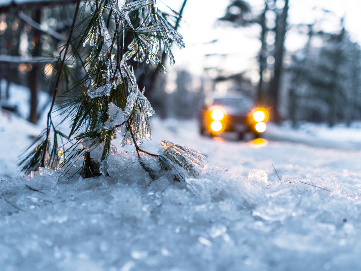 Ein Auto fährt durch eine Winter- und Eislandschaft.