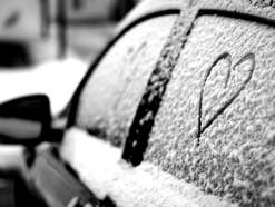 Schneebedecktes Auto mit Herz in der Seitenscheibe