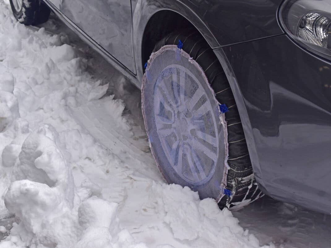 Ein Auto mit Schneesocken im tiefen schnee.