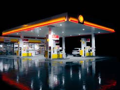 Eine beleuchtete Tankstelle in einer stürmischen Nacht.