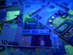 Mehrere Euro-Scheine übereinander unter Schwarzlicht