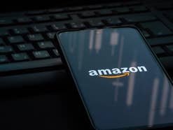 Laptoptastatur, darauf ein Smartphone mit geöffneter Amazon-App