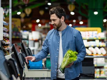 Ein Mann steht an einer Supermarktkasse