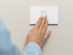 Eine Frau drückt einen Lichtschalter