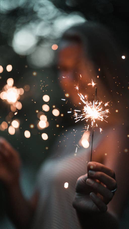 Eine Wunderkerze zu Silvester in einer Hand