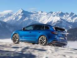 Skoda Enyaq in Blau im Schnee vorBergpanorama.