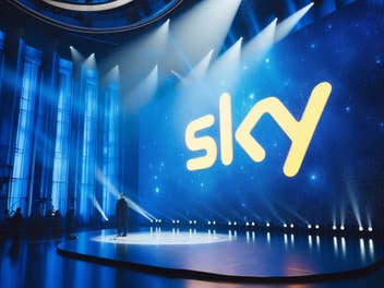 Sky-Logo auf einer Bühne im Scheinwerferlicht.
