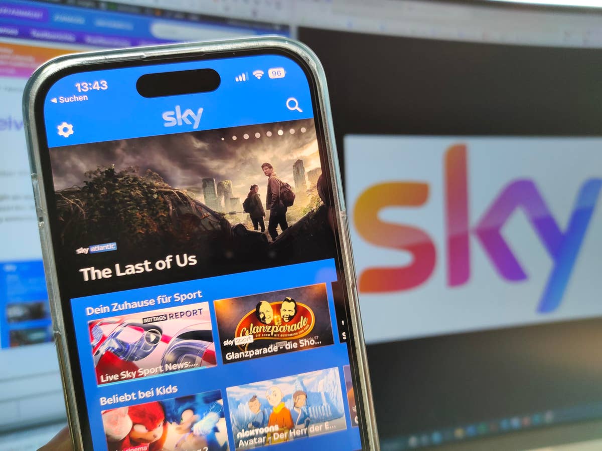 Sky Go auf einem Smartphone mit Sky Logo im Hintergrund.