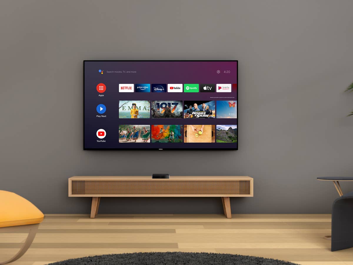 Ein Smart TV, der an der Wand über einem Sideboard hängt, mit aktiven Apps.