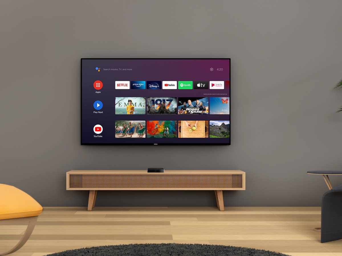 A Smart TV hanging on the wall above a sideboard with apps running.