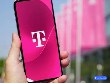 Smartphone auf dem das Telekom-Logo zu sehen ist, im Hintergrund ein Telekom-Gebäude, KI-generiert