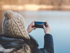 Smartphone im Winter Dick angezogene Frau mit Handy in der Hand