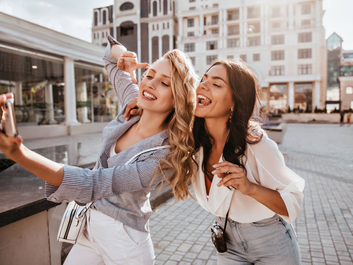 Frauen machen ein Smartphone-Selfie Zwei Freundinnen machen ein Selfie in der Stadt