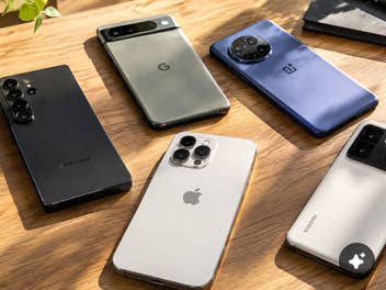 Smartphones immer teurer: 3 Ursachen und 8 Spartipps Smartphones liegen auf einem Schreibtisch im Sonnenlicht.