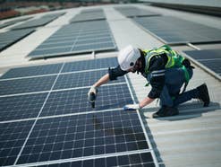 Handwerker bei Installation einer PV-Anlage auf dem Dach