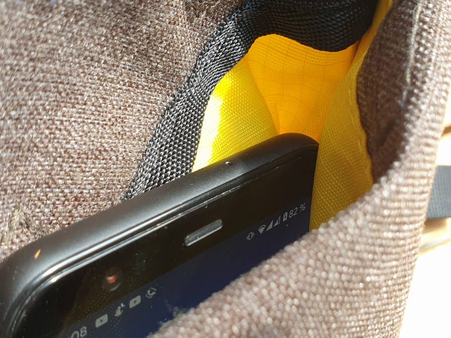 Smartphone wird in der Außentasche des Solar-Rucksacks per Qi aufgeladen.